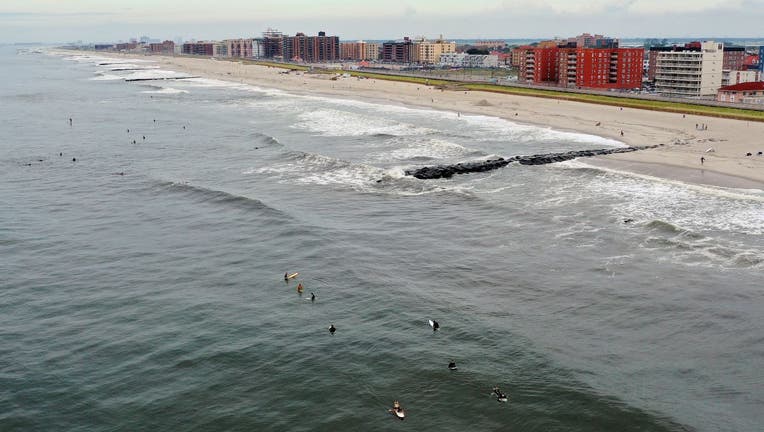 In an aerial view, surfers flock to the beach as wave heights elevate in advance of Hurricane Henri on August 21, 2021 in Long Beach, New York. 