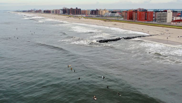 In an aerial view, surfers flock to the beach as wave heights elevate in advance of Hurricane Henri on August 21, 2021 in Long Beach, New York.