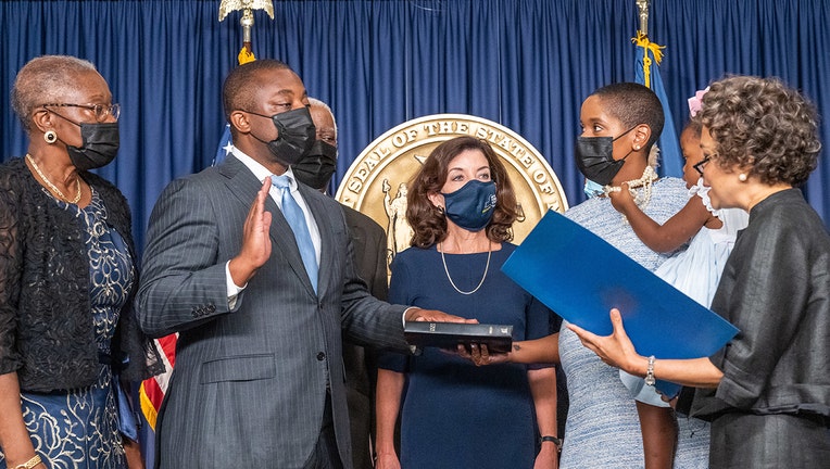 Brian Benjamin is surrounded by family and the governor as he takes the oath of office