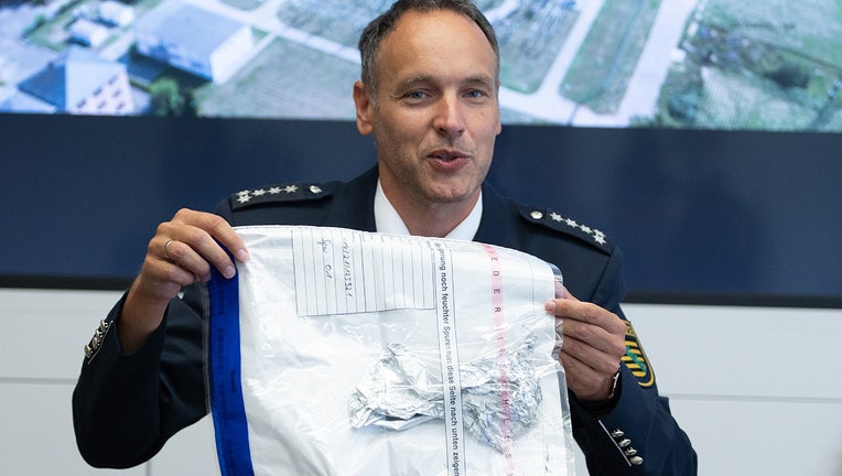 Thomas Geithner, police spokesman, shows the remains of the metal foil of a balloon discovered in the substation Dresden-Süd during a press conference.(Photo by Sebastian Kahnert/picture alliance via Getty Images)