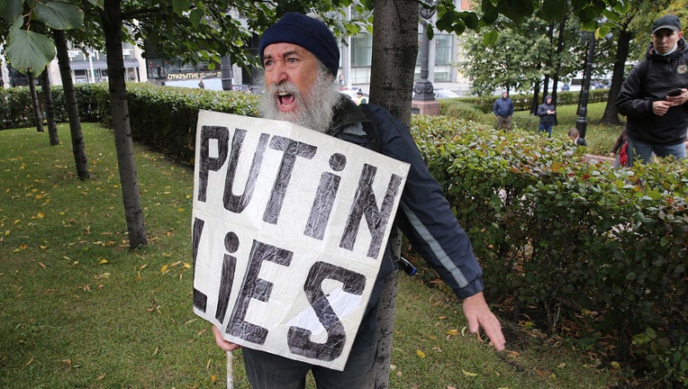 An activist with poster read: "Putin lies" shouts during the protest against the results of 2021 Parliamentary Elections, called by Communist Party, at Pushkinskaya Square, on September 25, 2021 in Moscow, Russia.(Photo by Mikhail Svetlov/Getty Images)