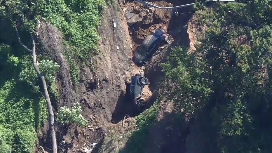 Aerial view of two cars stuck in a sinkhole caused by a landslide