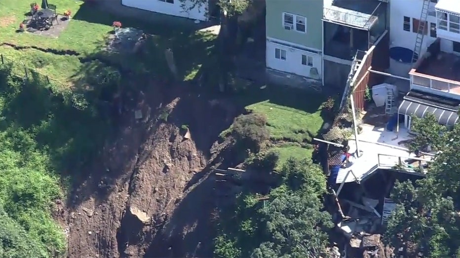 Aerial view of a collapsed deck and a collapsed backyard of suburban homes