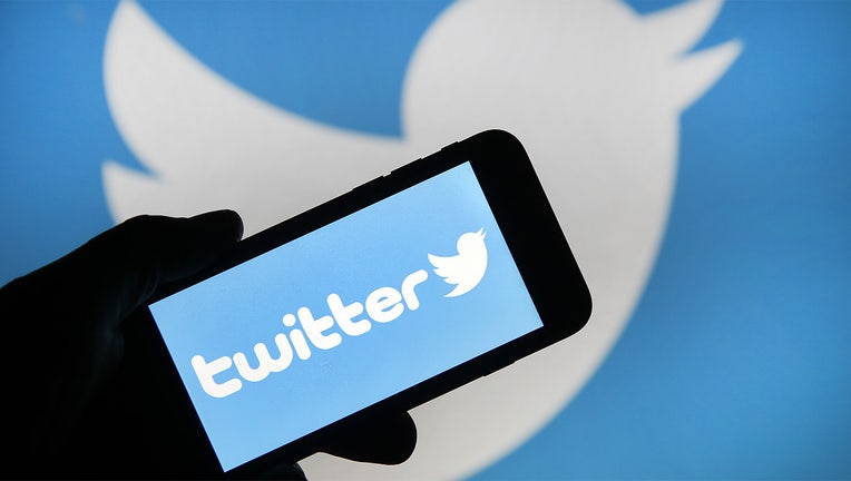 In this photo illustration the Twitter logo is displayed on the screen of an iPhone in front of a computer screen displaying a Twitter logo. (Photo by Chesnot/Getty Images)