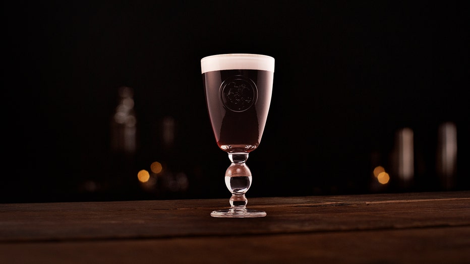 A foamy Irish coffee cocktail in a stem glass