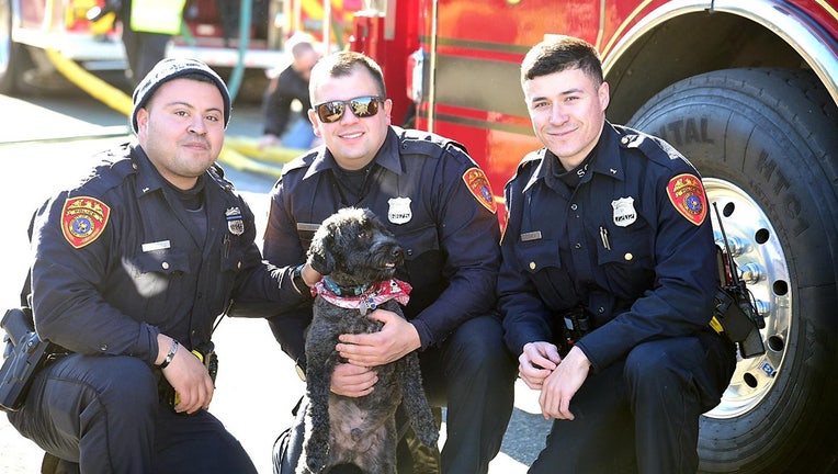 Officers Zakary Goldbach, Joaquin Castillo and Justin Oshea are reunited with the rescued dog.