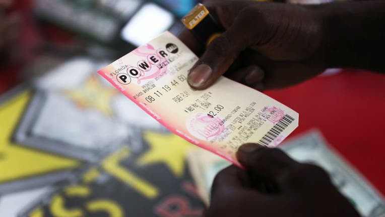 FILE - A person holds a Powerball ticket at the Shell Gateway store on March 26, 2019, in Boynton Beach, Florida. (Photo by Joe Raedle/Getty Images)