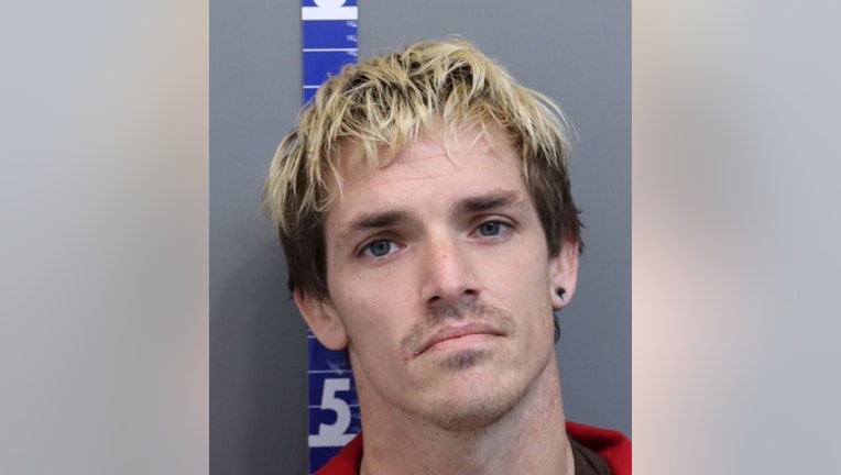 Booking photo of a man with blond hair and an earring