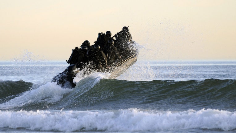 In this handout provided by the U.S. Navy, Students in Sea Air and Land (SEAL) qualification training navigate the surf off the cost of Coronado during a maritime operations training exercise October 28, 2010 in Coronado, California. (Photo by Blake Midnight/US Navy via Getty Images)