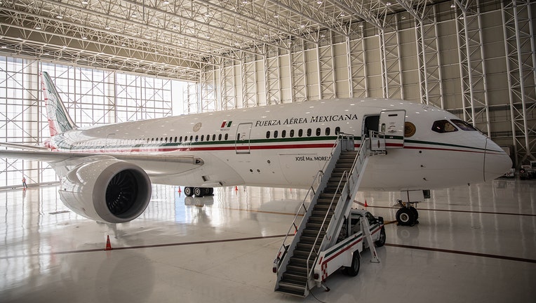 A white Boeing two-engine jetliner in a hangar