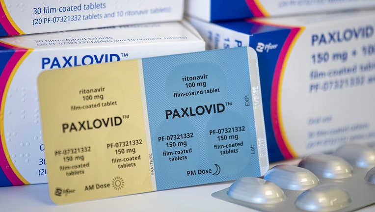 Boxes and a blister pack of pills called PAXLOVID