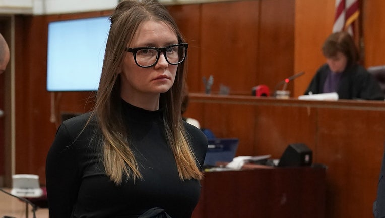 Fake German heiress Anna Sorokin wearing black glasses and a black outfit inside a courtroom