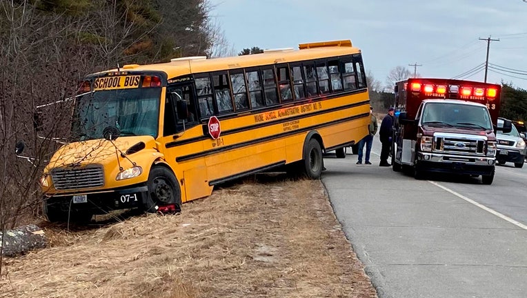 This photo provided by the Topsham Police Department shows a school bus that students steered to safety after the 77-year-old male driver suffered a medical event that left him incapacitated, Monday, March 14, 2022, in Topsham, Maine. The driver, Arthur McDougall, died later that day. Two students assisted in stopping the bus while a third student attempted to administer first aid. (Topsham Police Department via AP)