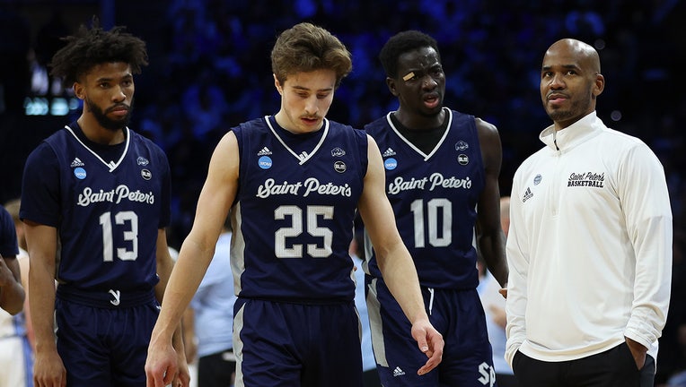 Head coach Shaheen Holloway of the St. Peter's Peacocks talks with Isiah Dasher #13, Doug Edert #25 and Fousseyni Drame #10 of the St. Peter's Peacocks during the second half of the game against the North Carolina Tar Heels in the Elite Eight round game of the 2022 NCAA Men's Basketball Tournament at Wells Fargo Center on March 27, 2022 in Philadelphia, Pennsylvania. (Photo by Patrick Smith/Getty Images)