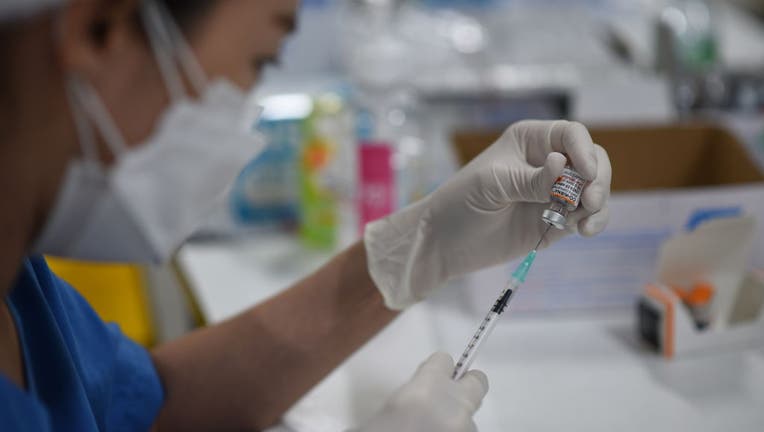 A health worker prepares covid-19 vaccine for young children