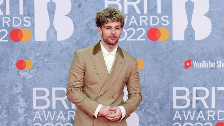 Singer Tom Grennan wearing a tan suit