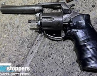 A dark-colored revolver; the grip appears to be wrapped in black tape