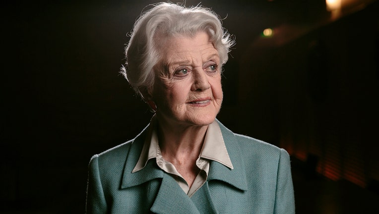 Head and shoulders photo of Angela Lansbury; she looks to her left; she wears a tan shirt and light green suit