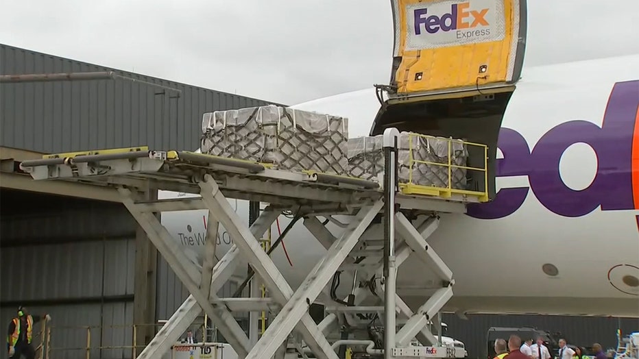 Containers on a platform next to a FedEx plane