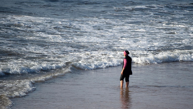 A Moroccan woman wearing a "burkini", a full-body swimsuit designed for Muslim women, enters the sea at Oued Charrat beach. (Photo credit FADEL SENNA/AFP via Getty Images)