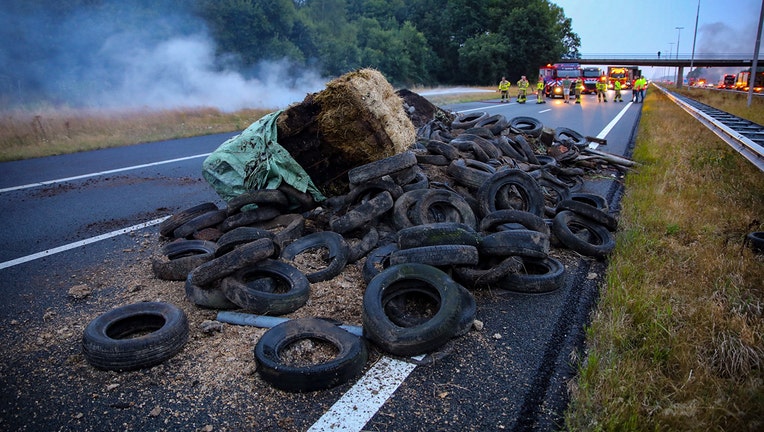 This photograph taken on July 27, 2022, shows a pile of manure, tires, and hay bales on fire on the A50 highway with firefighters in the background during a farmers' demonstration against the government's nitrogen policy, in Apeldoorn, the Netherlands, (Photo by ANP/AFP via Getty Images)