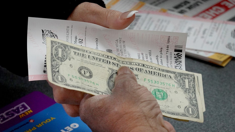 A customer purchases a Mega Millions lottery ticket. (Photo by Scott Olson/Getty Images)