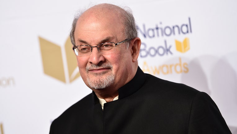 Head and shoulders photo of author Salman Rushdie; he is wearing a black outfit and thin-framed glasses