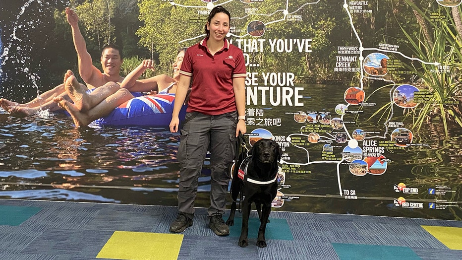 Detector dog Zinta with handler at Darwin airport. (Agriculture, Fisheries and Forestry)
