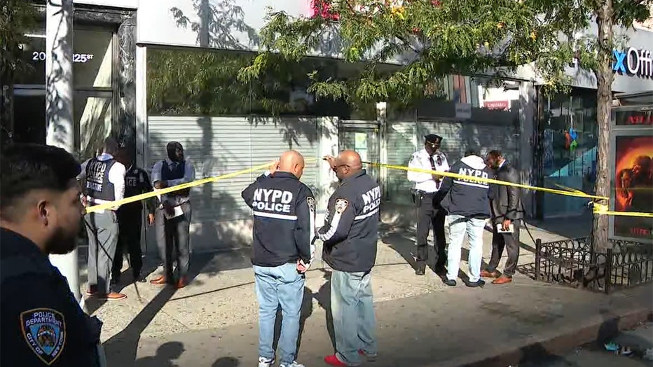 Several police officers at a crime scene on a sidewalk in Harlem