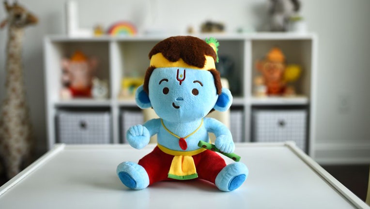 A promotional photo from Modi Toys of a plush toy depicting the Hindu deity Lord Krishna as a baby