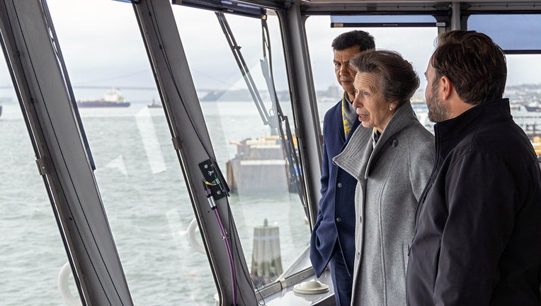 Three people, including Princess Anne, in the pilothouse of a ferry