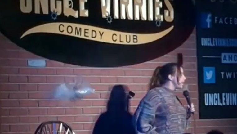 A beer can explodes as it hits the wall behind Ariel Elias at Vinnie's Comedy Club in Point Pleasant Beach, N.J.