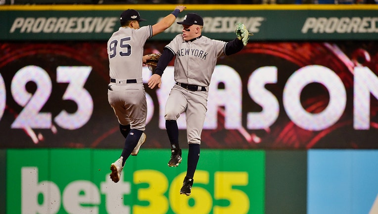 New York Yankees' Oswaldo Cabrera, left, and Harrison Bader celebrate after the Yankees defeated the Cleveland Guardians in Game 4 of a baseball AL Division Series, Sunday, Oct. 16, 2022, in Cleveland. (AP Photo/Phil Long)