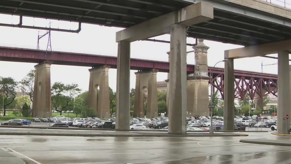 A parking lot underneath a railroad trestle and the RFK Bridge.