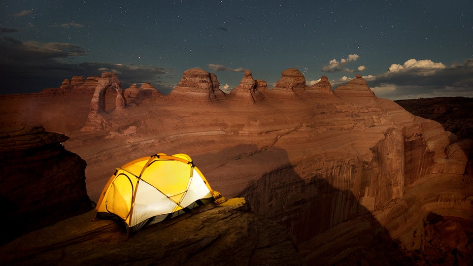 Twilight falls over Delicate Arch and other red rock formations in Arches National Park, one of Utah’s five national parks. (Photograph by Chad Copeland, Nat Geo Image Collection)