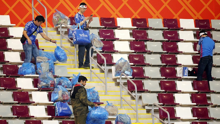 Japanese fans clear rubbish from the stands during the FIFA World Cup Qatar 2022 Group E match between Germany and Japan at Khalifa International Stadium on November 23, 2022 in Doha, Qatar. (Photo by Alex Grimm/Getty Images)
