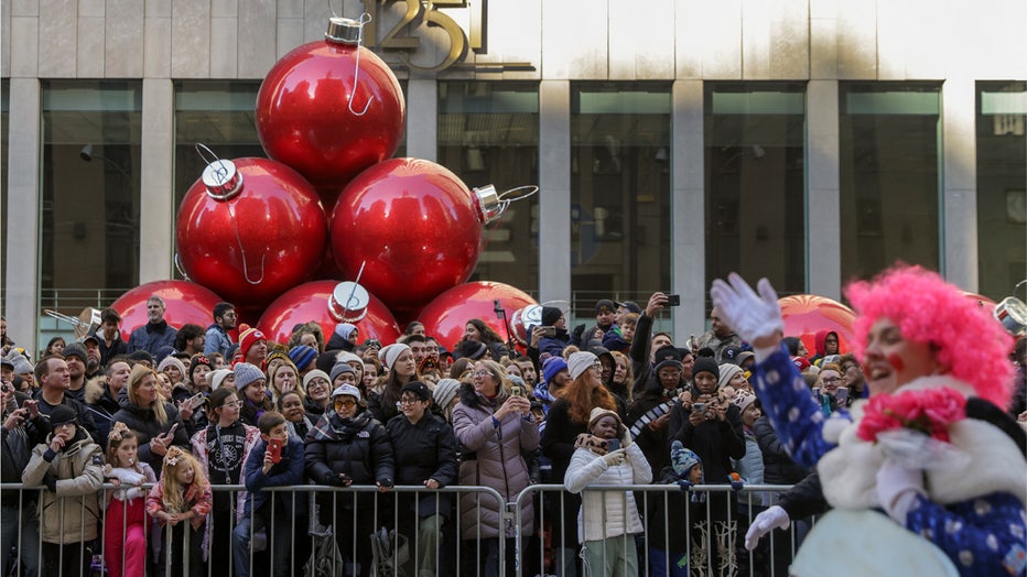 Spectators line Sixth Avenue as they watch clowns, floats and balloons go by during the Macy's Thanksgiving Day Parade, Thursday, Nov. 24, 2022, in New York. (AP Photo/Jeenah Moon)