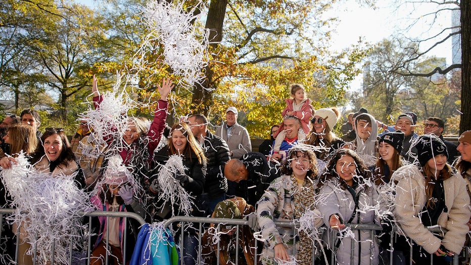 Spectators toss confetti as the parade makes its way down Central Park Avenue West during the Macy's Thanksgiving Day Parade, Thursday, Nov. 24, 2022, in New York. (AP Photo/Julia Nikhinson)