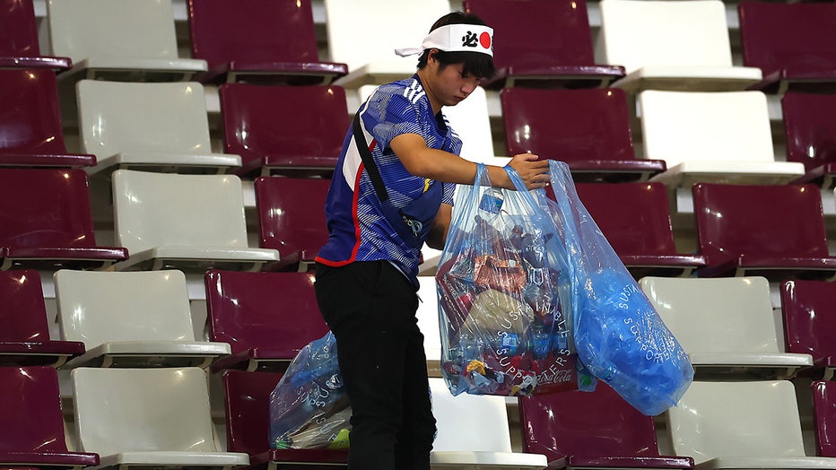 A Japanese fan clears rubbish from the stands during the FIFA World Cup Qatar 2022 Group E match between Germany and Japan at Khalifa International Stadium on November 23, 2022 in Doha, Qatar. (Photo by Alex Grimm/Getty Images)