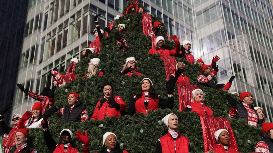 Performers on the Macy's Singing Christmas Tree float wave to spectators during the Macy's Thanksgiving Day Parade, Thursday, Nov. 24, 2022, in New York. (AP Photo/Jeenah Moon)