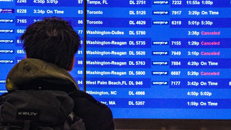Passengers check flight departure schedules at the Delta Terminal at LaGuardia Airport in New York on Friday, Dec. 23, 2022.  (AP Photo/Bebett Matthews)