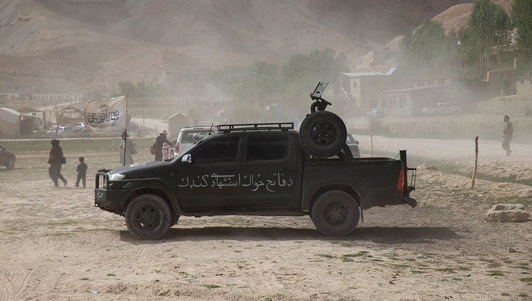 A military jeep is parked near the national flag of the Islamic Emirate of Afghanistan during a dust storm on August 12, 2022 in Bamian, Afghanistan.(Photo by Nava Jamshidi/Getty Images)