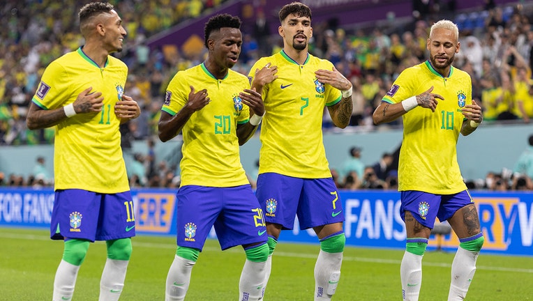 O brasileiro Vinicius Jr. dança com Rafinha, Lucas Paquetá e Neymar após marcar o primeiro gol da seleção durante a partida da Copa do Mundo do Catar 2022 pelas oitavas de final entre Brasil (4) e Coreia do Sul (1) em 5 de dezembro de 2022 em Doha .  (Foto de Simon Prouty/Anychance/Getty Images)