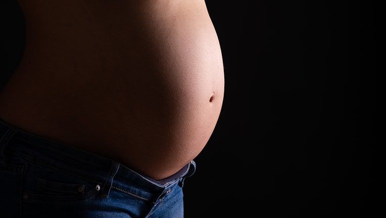 In this photo illustration, a pregnant woman shows her belly. (Photo by Katja Knupper/Die Fotowerft/DeFodi Images via Getty Images)