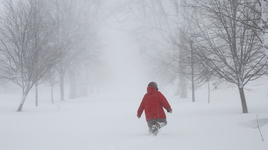 A person walks on the street as a winter storm rolls through Western New York Saturday, Dec. 24, 2022, in Amherst N.Y. (AP Photo/Jeffrey T. Barnes)