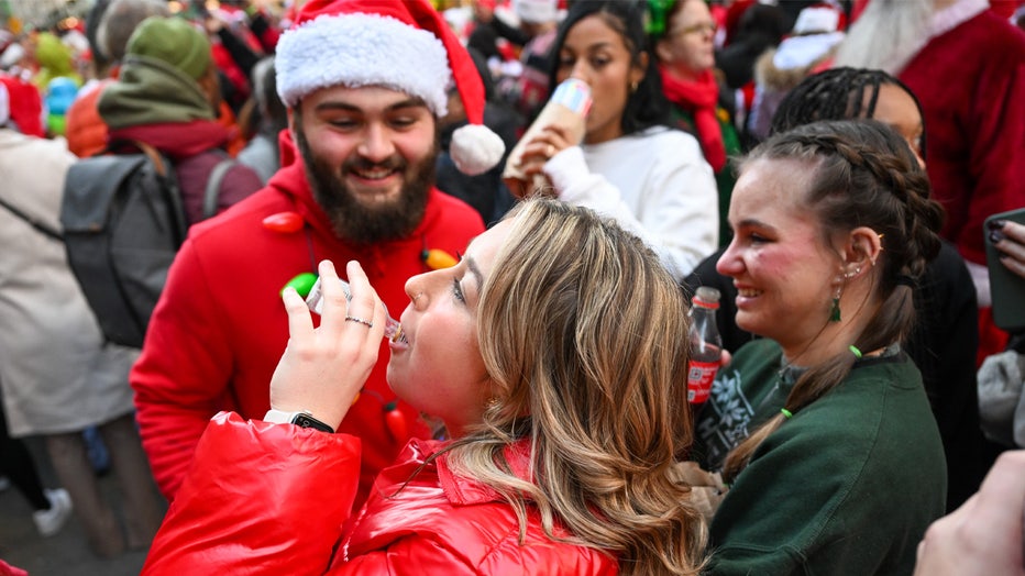 NEW YORK, NEW YORK - DECEMBER 10: People dressed in Santa Claus costumes participate in SantaCon on December 10, 2022 in New York City. SantaCon is an annual Christmas-themed pub crawl that raises money for charity. This year, SantaCon created a map and partnered with the app, Wolfie, to display real-time updates about lines, venues, and friends’ locations. (Photo by Alexi Rosenfeld/Getty Images)