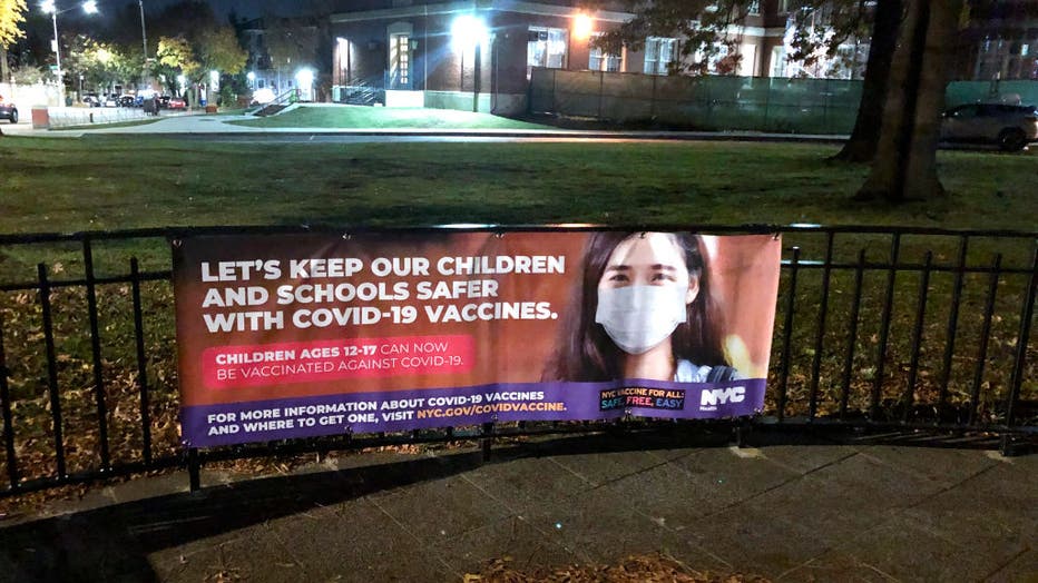 Keep Children and schools safer with Covid 19 vaccines banner outside Forest Hills High school, Queens, New York