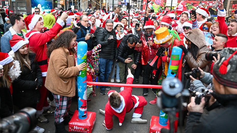 NEW YORK, NEW YORK - DECEMBER 10: People dressed in Santa Claus costumes participate in SantaCon on December 10, 2022 in New York City. SantaCon is an annual Christmas-themed pub crawl that raises money for charity. This year, SantaCon created a map and partnered with the app, Wolfie, to display real-time updates about lines, venues, and friends’ locations. (Photo by Alexi Rosenfeld/Getty Images)