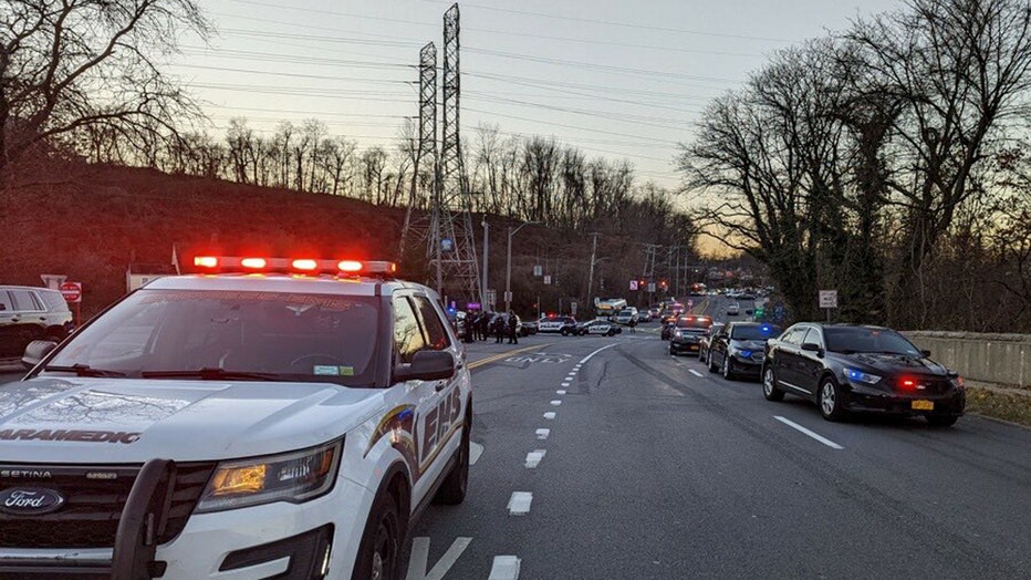 EMS and police vehicles with emergency lights flashing on a road