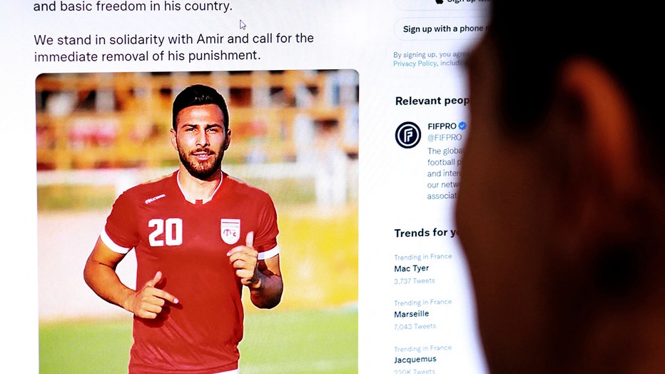 A person in the Cypriot capital Nicosia checks a tweet on December 13, 2022, by the International Federation of Professional Footballers (FIFPRO) regarding the reported risk of Iranian footballer Amir Nasr-Azadani being sentenced to death. (Photo by /AFP via Getty Images)